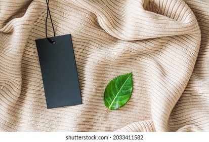 Clothing Tag And Green Leaf As Eco-friendly Flatlay Background, Sustainable Fashion And Brand Label Concept.