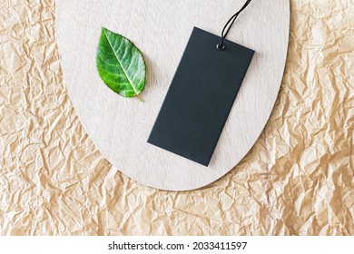 Clothing Tag And Green Leaf As Eco-friendly Flatlay Background, Sustainable Fashion And Brand Label Concept.