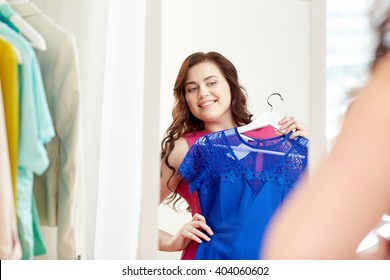 Clothing, Wardrobe, Fashion, Style And People Concept - Happy Plus Size Woman With Dress On Hanger At Mirror At Home