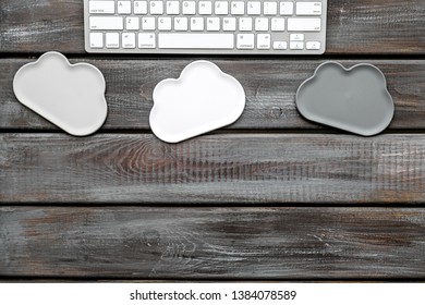 cloud computing concept with clouds and keyboard on wooden background top view space for text
