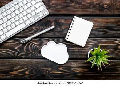 cloud computing concept with clouds, pen, notebook and keyboard on wooden background top view copy space