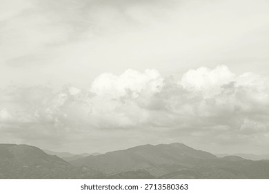 Cloud Dancer colored overcast sky with a few clouds above sea and mountains. Monochrome texture 2026. Color of the year