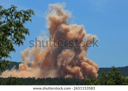 a cloud of dust and dirt in the quarry from the explosion of explosives