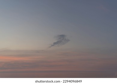 A cloud in the evening sunset sky in the form of a bird, a dragon, an angel, a fantasy animals.