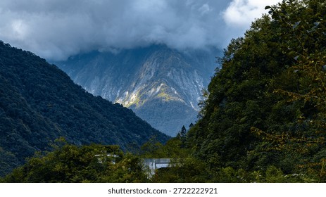 [Cloud Gap Mountain Light, Emerald Ridge Gilding] In the mountain stream torn open by clouds and mist, the gilding light envelops the tiered emerald ridges, as if blending the spiritual elegance of the wilderness into the shadows, suitable for cultural tourism promotion, natural aesthetics, and outdoor healing commercial visual scenes