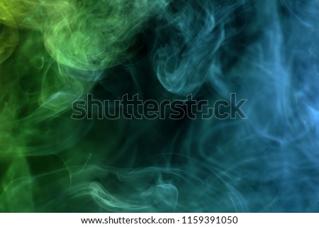 Cloud of  green and blue smoke on a black isolated background. Background from the smoke of vape
