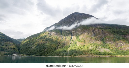 The cloud is hugging the mountain.