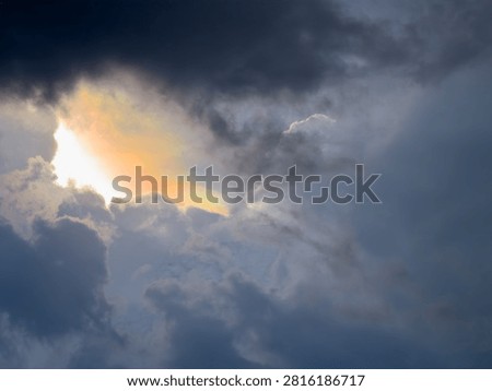 Cloud iridescence is a phenomenon where clouds radiate a beautiful pastel rainbow of colors as a storm brews in the dark, gloomy sky.