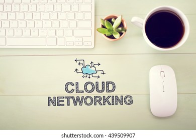 Cloud Networking concept with workstation on a light green wooden desk