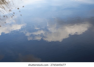 Cloud reflection on calm water surface with soft ripples natural abstract background