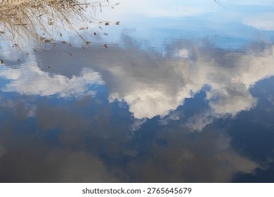 Cloud reflection on calm water surface with soft ripples natural abstract background