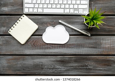 cloud service concept with clouds, notebook, plant and keyboard on wooden background top view mockup