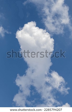 Cloud shaped like a rocketship heading upwards in a blue sky