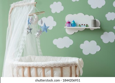 cloud stickers on green wall mosquito net on wooden cradle - Powered by Shutterstock