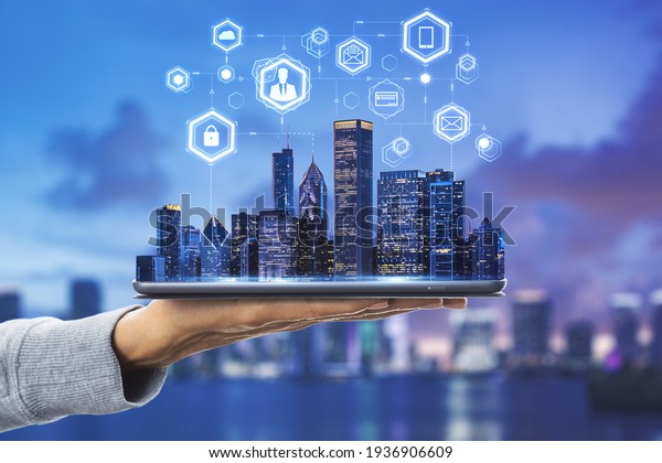 Cloud\
technology in smart city concept with human hand carries digital\
tablet with megapolis city skyscrapers and digital social network\
symbols above at blurry skyline\
background