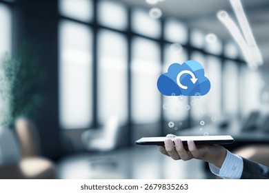 Cloud technology supports seamless data management efforts. A hand holds a tablet with a cloud icon representing digital data syncing in a modern office.