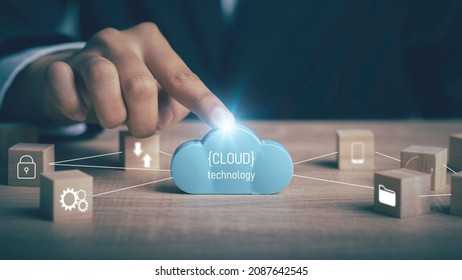 Cloud technology,Technology transformation, Data security concept. Businessman touch digital cloud  downloading and upload data application with information connecting icons line in wooden cube.



