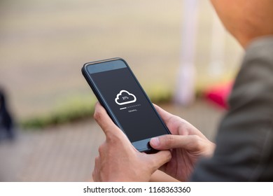 Cloud uploading concept on phone screen. Man hold phone doing cloud uploading at the outdoor. - Powered by Shutterstock