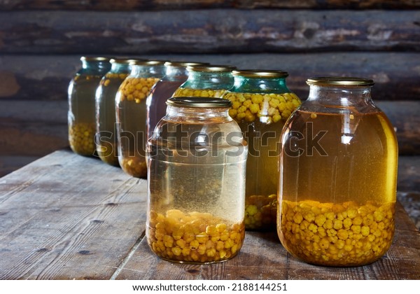 Cloudberry home canning, jars of berry compote are
on table in barn.