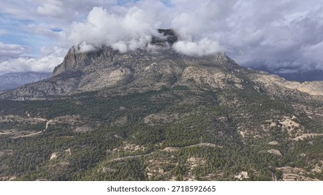 cloudcapped mountain in stormy light with low clouds wrapping summit dramatic geology scene shows rugged