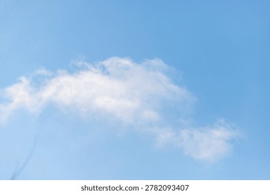 A cloudless blue sky with a single cloud. The sky is clear and bright, with no signs of rain or storm. The cloud is small and fluffy, adding a touch of whimsy to the otherwise plain sky
