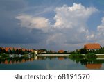 clouds of beginning thunderstorm over small lake and homes