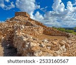 Clouds billow above the stacked red rock pueblo ruins of the Tuzigoot National Monument, Clarkdale, Arizona