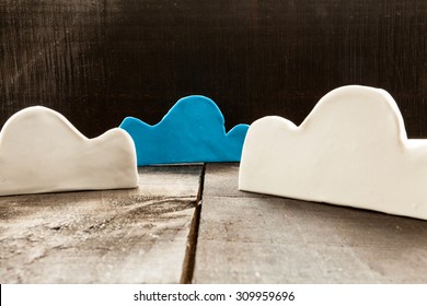clouds of clay imitating the clouds and the concept of technological clouding over wooden background as if it were an illustration