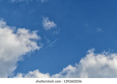 Clouds. Cloudy summer sky. Flying high in the sky plane with traces of engines.
