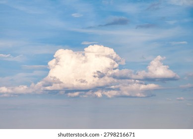 Clouds of different shapes are spread across a bright sky. The setting is outdoors, giving a clear view of the sky. This moment captures the beauty of nature in an open area.