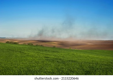 Clouds Of Dust On The Hills Of Plowed Lands, Green Fields Winter Wheat And Problem Of Soil Erosion From The Wind