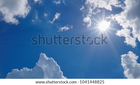 Clouds formations with sun flare over bluesky background. Copy space