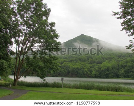 clouds hover on sharp top mountain peak above Abbott Lake; Bedford, VA, USA
