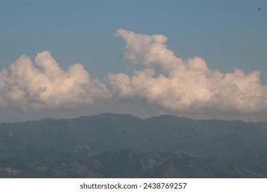 Clouds hover over a lush mountain landscape