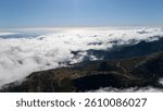 Clouds hovering over rolling hills in a breathtaking landscape during a clear day