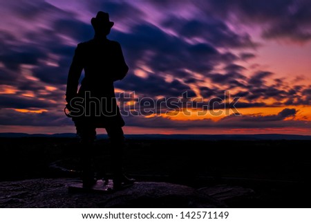 Clouds move behind a statue in a long exposure taken after sunset from Little Round Top in Gettysburg, Pennsylvania.