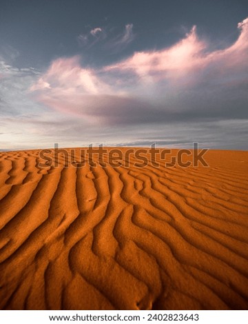 Clouds moving over a red sand dune at sunset in Outback Australia