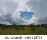 clouds over field and forest