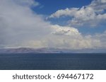 Clouds over lake Sevan and mountain range at background. Gegharkunik Province, Armenia