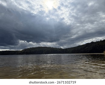 Clouds over the river while sun shines through 