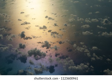 Clouds over the sea with reflections of colors. Photograph taken at sunrise from an airplane