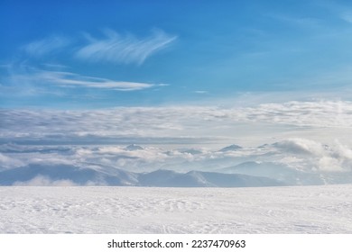 Clouds over a snow-covered mountain range. Winter mountain landscape. 