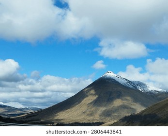 Clouds over snowy summit mountain 