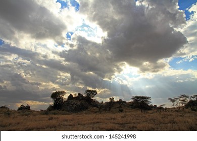 Clouds part to shine the sun's rays down upon the Serengeti plains in Tanzania