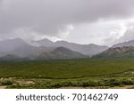Clouds pour rain down on the mountains and valley below in Denali National Park, Alaska.