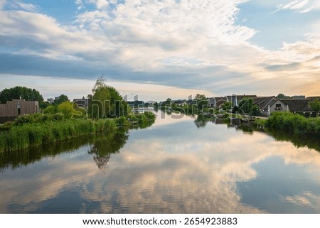 Clouds are reflected in the calm waters of the river Rotte near Oud Verlaat, just north of Rotterdam, Netherlands.