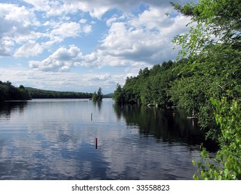 Clouds Reflected In The Clear Water Of A Maine Lake.