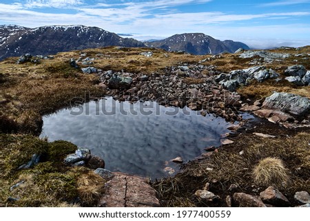 Clouds are reflected in the water. Hiking the mountains Skåldalsnipa (603 meter), Skåldalsfjellet (718 meter), Herlandsfjellet (696 meter) and Garnesrinden (625 meter) in Bergen, Norway