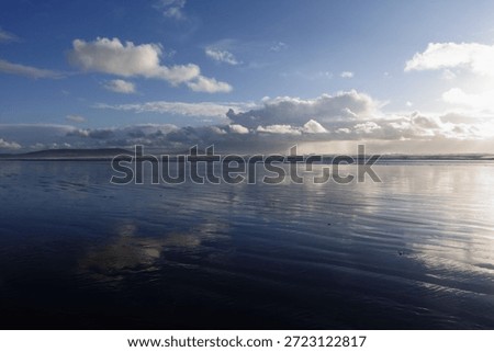 Clouds reflected in the wet sand on the beautiful beach at Pendine, Carmarthenshire, Wales, UK.
