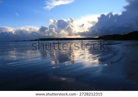 Clouds reflected in the wet sandy on the beach at Pendine, Carmarthenshire, Wales, UK.